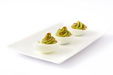 Beyaz arka plan üzerinde izole guacamole ile yumurta dolması
