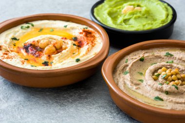 Farklı humus kase. Nohut Humus, avokado humus ve mercimek humus gri taş