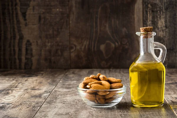 Aceite de almendras en botella sobre mesa de madera — Foto de Stock