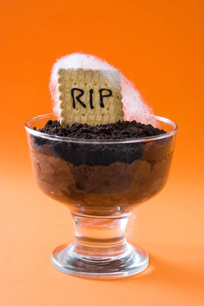 Drôle de mousse au chocolat Halloween avec biscuit tombeau sur fond orange — Photo
