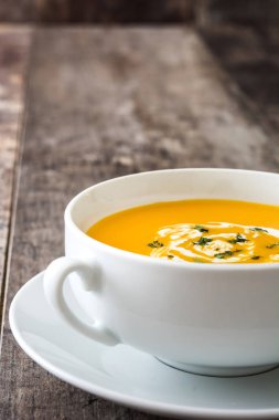 ahşap masa üzerinde beyaz kase kabak çorbası