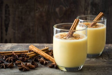 Tarçın ahşap masa üzerinde ev yapımı yumurta likörü. Tipik Noel tatlısı. Boşaltmak