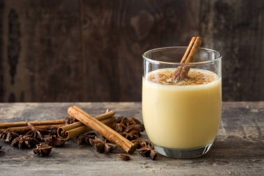 Tarçın ahşap masa üzerinde ev yapımı yumurta likörü. Tipik Noel tatlısı. Boşaltmak