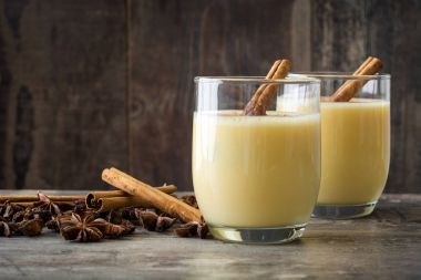 Tarçın ahşap masa üzerinde ev yapımı yumurta likörü. Tipik Noel tatlısı. Boşaltmak