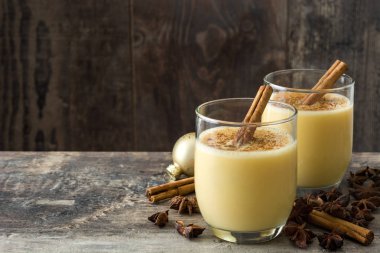 Tarçın ahşap masa üzerinde ev yapımı yumurta likörü. Tipik Noel tatlısı. Boşaltmak
