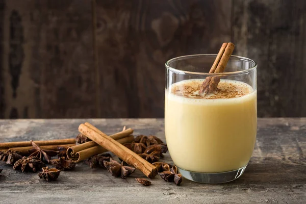 Tarçın ahşap masa üzerinde ev yapımı yumurta likörü. Tipik Noel tatlısı. Boşaltmak