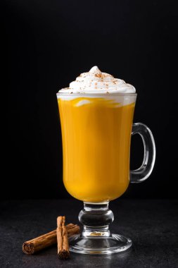 Siyah arka plan üzerine baharatlı sütlü balkabağı. 