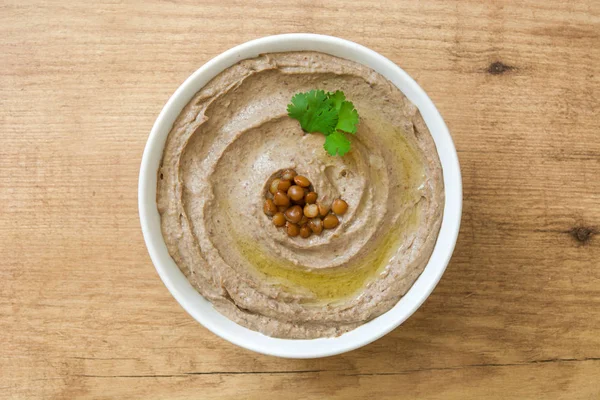 Hummus di lenticchia in ciotola su legno — Foto Stock