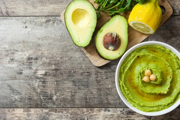 Avocado hummus i skål på træbord.Top view - Stock-foto