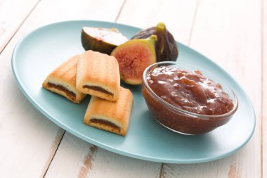 Beyaz ahşap masa üzerinde bir tost tatlı incir reçeli sürülür