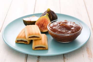 Beyaz ahşap masa üzerinde bir tost tatlı incir reçeli sürülür