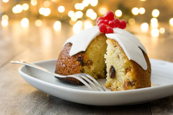 Weihnachtspudding und Weihnachtsbeleuchtung auf Holztisch — Stockfoto