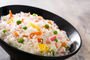 Çin kızarmış sebze ve omlet ahşap masa üzerinde siyah kase pilav