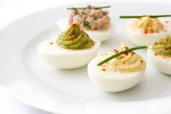 Varietà di uova ripiene con avocado e tonno in piatto isolato su fondo bianco — Foto Stock