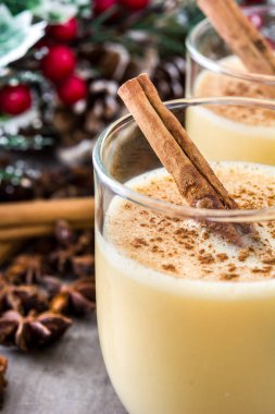 Tarçın ahşap masa üzerinde ev yapımı yumurta likörü. Tipik Noel tatlısı.