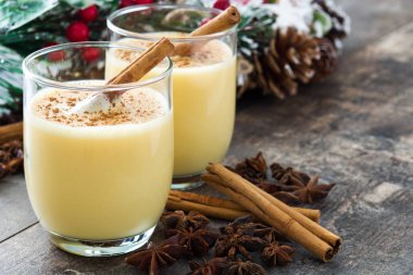Tarçın ahşap masa üzerinde ev yapımı yumurta likörü. Tipik Noel tatlısı. Boşaltmak