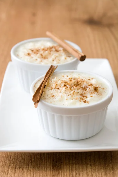 Arroz con leche. Pudding ryżowy z cynamonem na podłoże drewniane — Zdjęcie stockowe