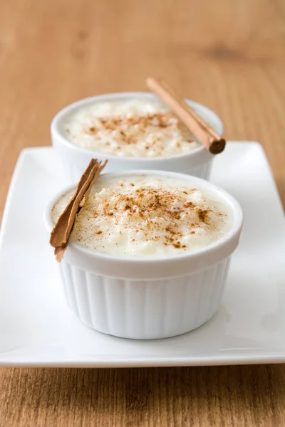 Arroz con leche. Pudding ryżowy z cynamonem na podłoże drewniane — Zdjęcie stockowe