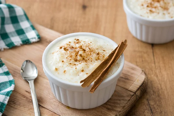 Arroz con leche. Pudding ryżowy z cynamonem na podłoże drewniane — Zdjęcie stockowe