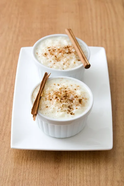 Arroz con leche. Pudding ryżowy z cynamonem na podłoże drewniane — Zdjęcie stockowe