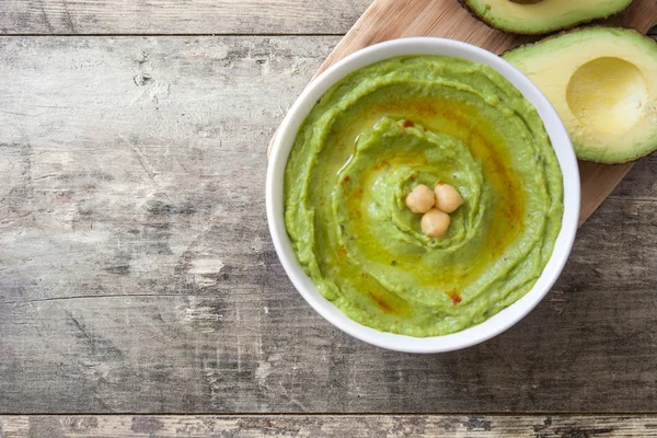 Avocado hummus in bowl on wooden table.Top view — Stock Photo, Image