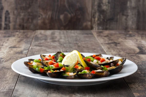 Mejillones al vapor con pimientos y cebolla sobre mesa de madera — Foto de Stock