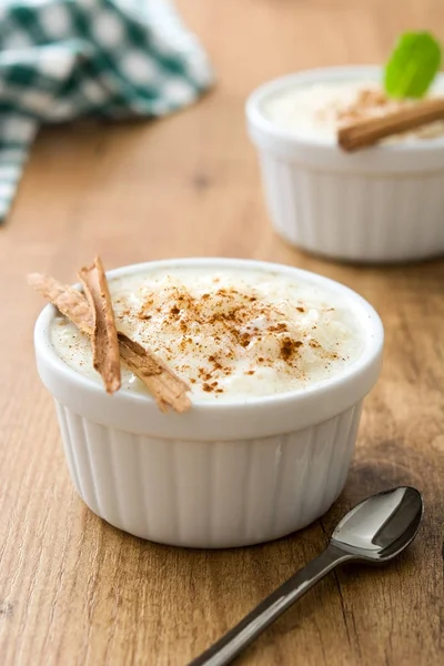 Arroz con leche. Pudding ryżowy z cynamonem na podłoże drewniane — Zdjęcie stockowe