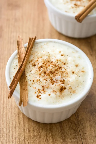 Arroz con leche. Pudding ryżowy z cynamonem na podłoże drewniane — Zdjęcie stockowe