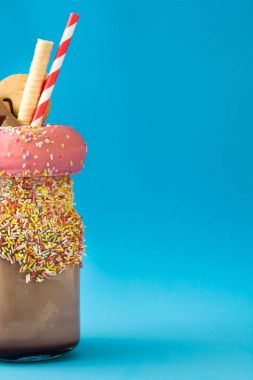 Aşırı milkshake ya da ucube sallamak üzerinde mavi arka plan. Boşaltmak