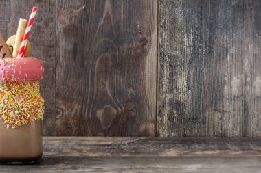 Aşırı milkshake ya da ucube sallamak ahşap masanın üzerinde. Boşaltmak