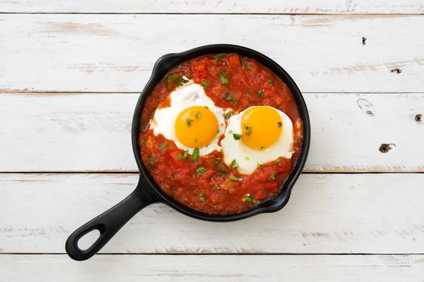 Мексиканські сніданок: Huevos rancheros у Залізний сковороді на білий дерев'яний стіл вид зверху — стокове фото