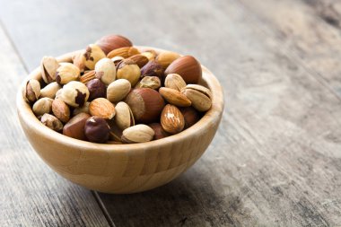 Ahşap masa ıslak zeminde çeşitli karışık Kuruyemiş. Boşaltmak