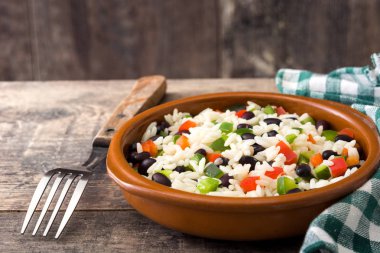 Geleneksel Küba pirinç, fasulye ve biber ahşap masa arka plan üzerinde. Moros y cristianos.