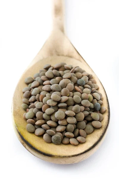 木のスプーンで白い背景で隔離のレンズ豆の粒 — ストック写真