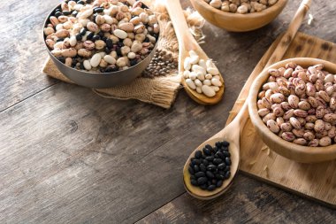 Ahşap kase çiğ çeşitli baklagiller. Üstten Görünüm kopya alanı ahşap tablo