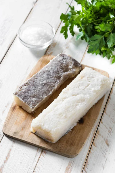 Salted dried cod on white wooden table. Typical Easter food