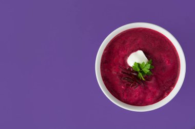 Pancar çorbası izole mor arka plan üzerinde beyaz kase. Üstten Görünüm tasarlamak