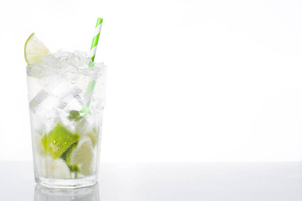 Caipirinha cocktail in glass on white background. Copyspace