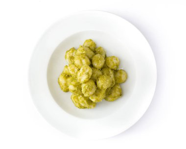 Gnocchi beyaz arka plan üzerinde izole plaka pesto soslu. Üstten Görünüm