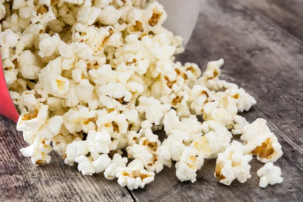 Ahşap masa üzerinde patlamış mısır ile çizgili kutusu.