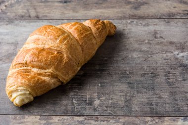 Kruvasan ahşap masa üzerinde. Boşaltmak