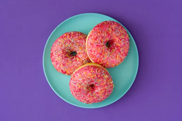 Donut Fosco Rosa Com Polvilhas Coloridas Fundo Violeta Vista Superior — Fotografia de Stock