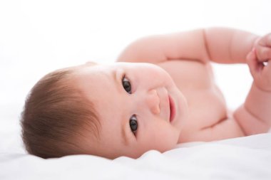 Beyaz arka plan üzerinde gülümseyen sevimli küçük bebek kız