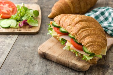 Peynir, jambon ve ahşap masa sebze ile kruvasan sandviç
