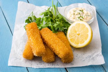 Çıtır çıtır kızarmış balık kroket limon ve mavi ahşap zemin üzerine sos ile