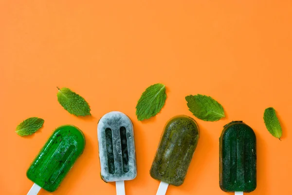 Zöld Fagyasztott Popsicles Narancssárga Háttérrel Felülnézet Copyspace — Stock Fotó