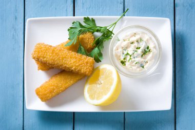 Çıtır çıtır kızarmış balık kroket limon ve mavi ahşap zemin üzerine sos. Üstten Görünüm
