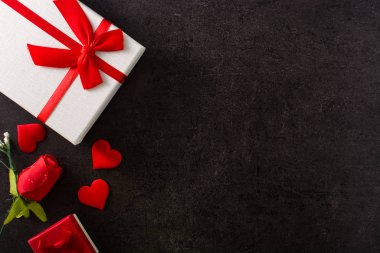 Hediye kutusu ve siyah arka planda kırmızı kalple süslenmiş kırmızı kağıt zarf. Boşluğu kopyala