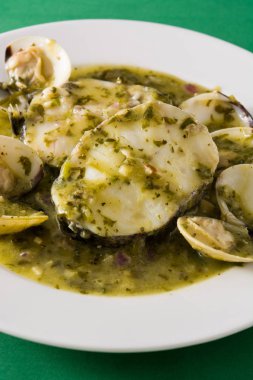 Yeşil soslu balık ve istiridye. Tipik İspanyol tarifi. Kapat.