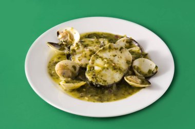 Yeşil arkaplanda yeşil soslu istiridye ve balık. Tipik İspanyol tarifi.. 